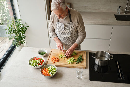 Senior Woman Preparing Fresh Healthy Vegetable Meal Bright Kitchen