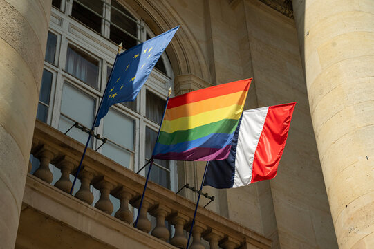flagi unii europejskiej, lgbt oraz francji na tle ściany budynku w słoneczny dzień