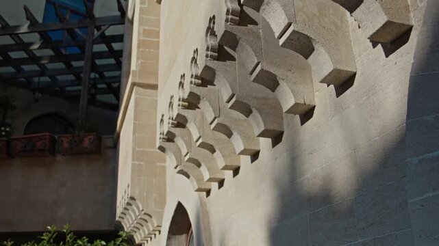 Detailed view of historic stone wall with decorative arches and shadows