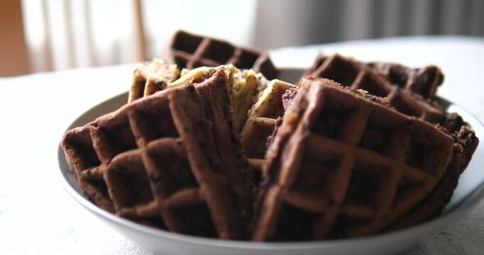 Close up of assorted sweet waffles stacked on a plate