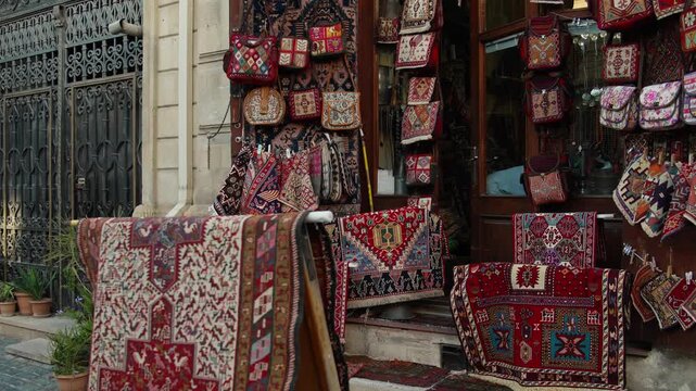 Outdoor display of colorful traditional rugs and bags at marketplace