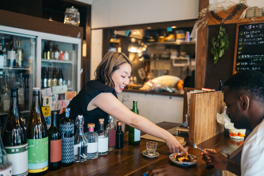 Smiling waitress in cozy Japanese restaurant