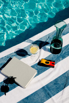 Still life of a book, a camera, sunglasses, and a glass of lemonade