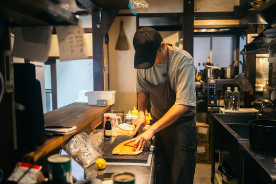 Cook handling fresh salmon in a Japanese kitchen