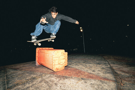 Skateboard Trick Over Rail at Night