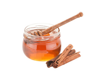 Honey Jar with Wooden Dipper and Cinnamon Sticks on Dark Surface © Md