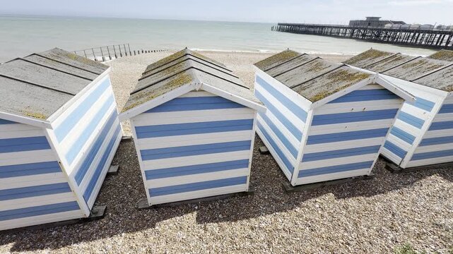 Row of traditional striped beach huts panning