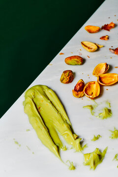 pistachio spread sits beside open shells and kernels on a table