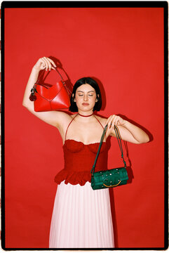 Woman posing with two fashion handbags