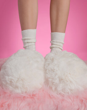 Womens legs wearing socks and the most fluffy slippers