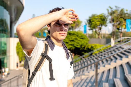 Man walking up the steps shields eyes from scorching sun