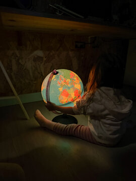 Child Explores a Glowing Globe
