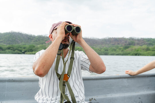 Man observing wildlife in a natural lake environment