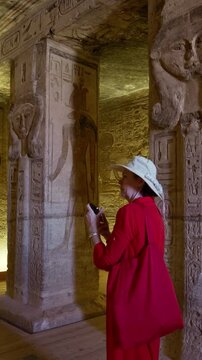 Woman in a red dress exploring the temple in Abu Simbel, Egypt.
