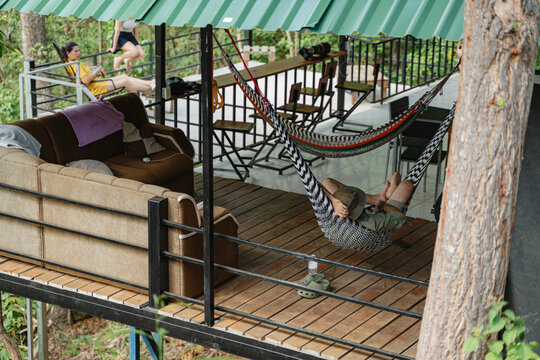 Man relaxing in hammock on elevated wooden deck in nature