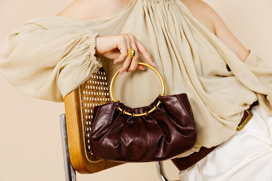 Woman holding stylish leather handbag 