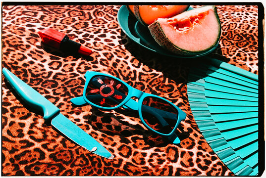 blue sunglasses, fan and melon on leopard print fabric, 35mm film