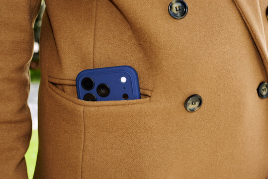 A smartphone in a jacket pocket on a sunny day