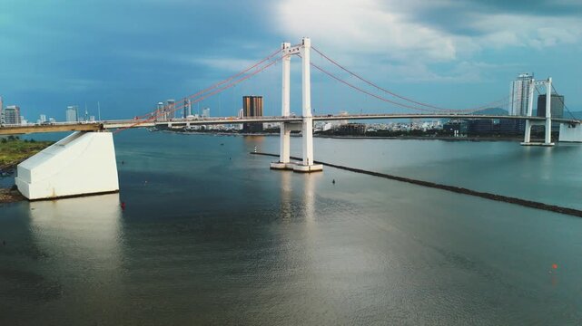 Thuan phuoc bridge spanning the han river in da nang, vietnam, connecting districts and symbolizing urban development with a modern city skyline and infrastructure under an evening sky