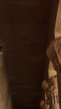 Ancient Egyptian Philae Temple. interior with massive carved stone columns covered in hieroglyphs, low angle view highlighting detailed reliefs and architectural grandeur.
