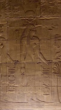 Detailed reliefs of ancient Egyptian deities and hieroglyphs carved on the walls of the Philae Temple. Egypt.