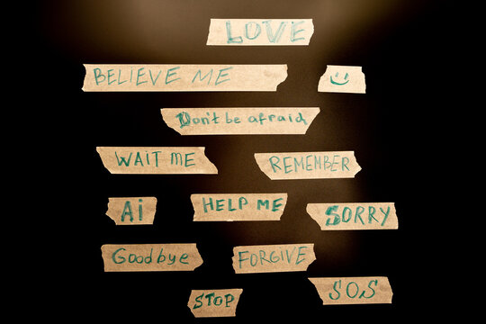 Messages written on paper strips on a dark background showing various simple phrases