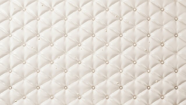 Tufted white leather texture with buttons and stitching pattern closeup