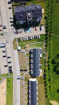 Real estate residential district aerial view apartment buildings parking lot cars. Bird's eye drone shot of contemporary blocks of flats and modern townhouse development with parking spaces