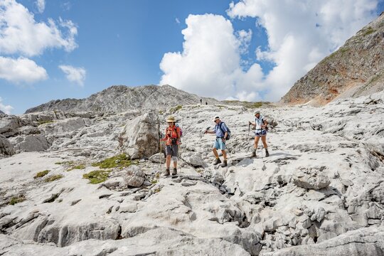 Three hikers in a landscape of washed-out karst rocks, Funtenseetauern, Steinernes Meer, Berchtesgaden National Park, Berchtesgadener Land, Upper Bavaria, Bavaria, Germany
