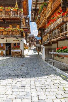 Paved footpath surrounded by old wooden houses, flower boxes on balconies and windows, historic village centre, Grimentz, Val d'Anniviers, Valais Alps, Canton Valais, Switzerland