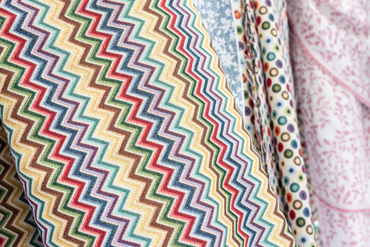 Background of assorted colorful pattern fabric rolls with zigzag design