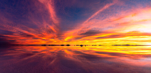 Sunset at the Salar de Uyuni, the world’s largest salt flat, under a sky ablaze with the colors of sunset, in the Andean region of Bolivia. © Creative Pixels