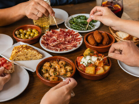 Disfrutar de una comida espa&ntilde;ola con tapas, mariscos y bebidas en una mesa