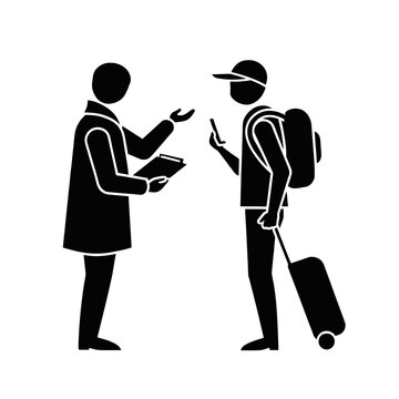 Traveler wearing a cap pulls a rolling suitcase while consulting with an airport staff member now.