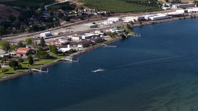 Aerial of waterfront town and marina on Columbia River in Pateros Washington with commercial buildings docks and industrial storage units