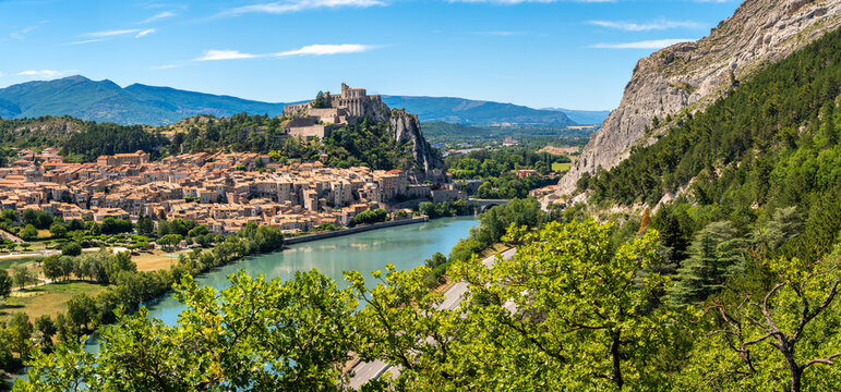 Elevated panoramic view of Sisteron and its Citadel overlooking the Durance River in summer. Historic town in Alpes-de-Haute-Provence, France