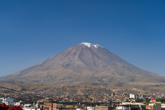 The snow-capped El Misti volcano towering over the sprawling city of Arequipa under a clear blue sky in Peru.