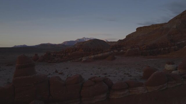 An aerial flyover sandstone rock formation and hoodoos at sunrise, Little Egypt, Utah