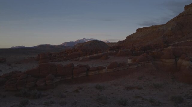 An aerial flyover sandstone rock formation and hoodoos at sunrise, Little Egypt, Utah