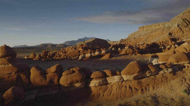 An aerial flyover sandstone rock formation and hoodoos at sunrise, Little Egypt, Utah