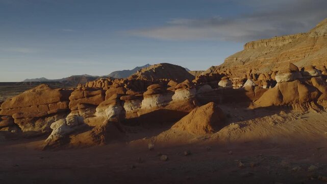 An aerial flyover sandstone rock formation and hoodoos at sunrise, Little Egypt, Utah