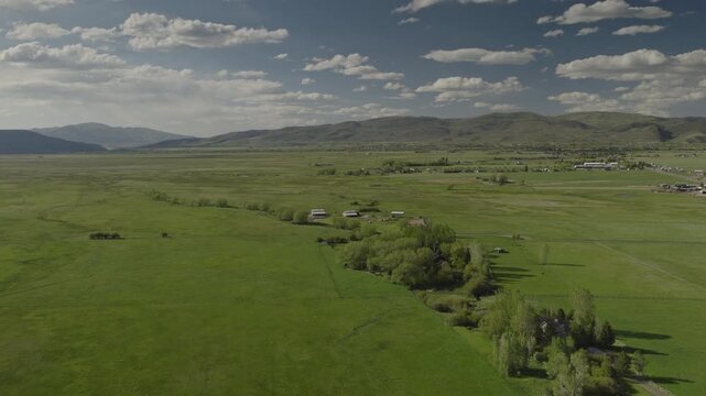An aerial flyover of marshland and meadows near rural farms, Kamas, Utah