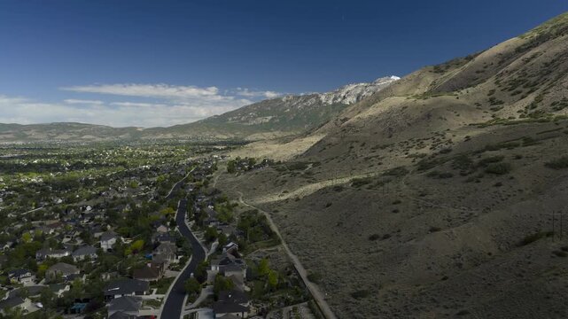 An Aerial timelapse, Hyperlapse, of clouds moving over a suburban community near the Wasatch mountains, Cedar Hills, Utah