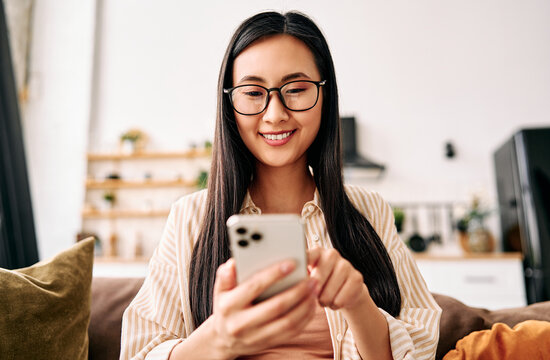 Young woman using smartphone at home.
