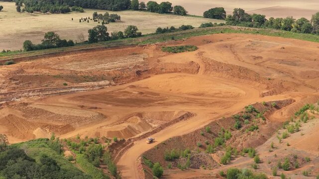 Earthmoving Excavator Digs Earth in Large Rural Open Pit Mine