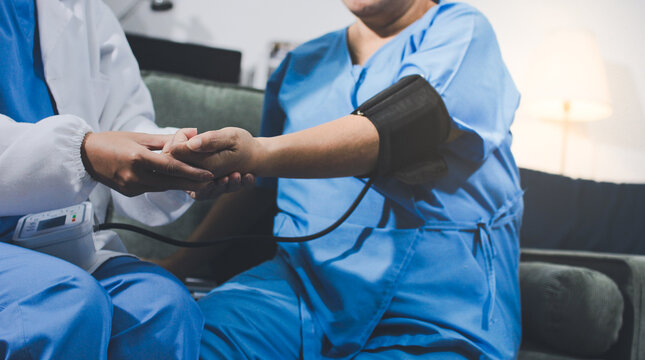 Doctor taking patient's blood pressure with a digital monitor, healthcare checkup, medical examination