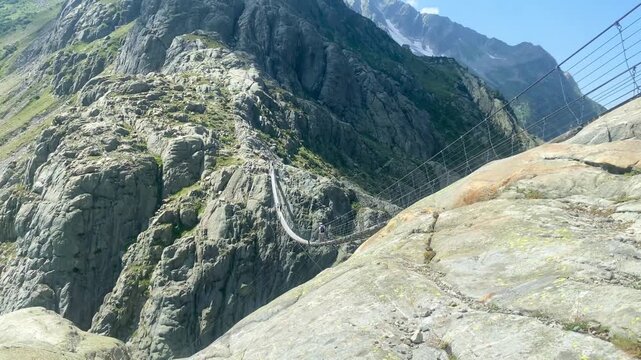 High angle view of the dramatic Trift Bridge suspension footbridge spanning a deep alpine gorge in Switzerland