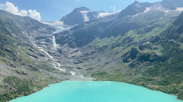 High angle view of turquoise Triftsee lake and Trift Glacier waterfall in Switzerland