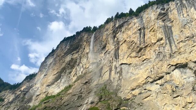 Low angle view of Staubbach Falls cascading down the massive limestone cliffs in Lauterbrunnen Switzerland
