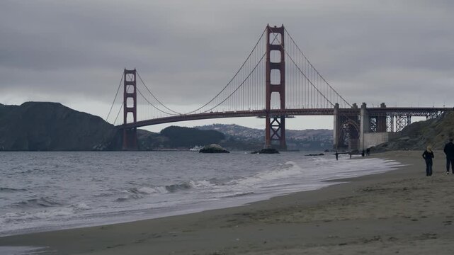 San Francisco Golden Gate Bridge Beach Foreground With Multiple Walkers And Overcast Sky - Wide Shot
